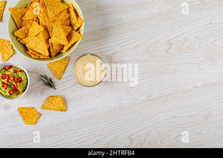 Directement au-dessus d'une dose de deux sauces à trempette servies avec des chips de nacho dans un bol sur une table avec un espace vide Banque D'Images