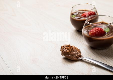 Fraises avec dessert au chocolat servies dans des bols en verre sur une table avec espace vide Banque D'Images