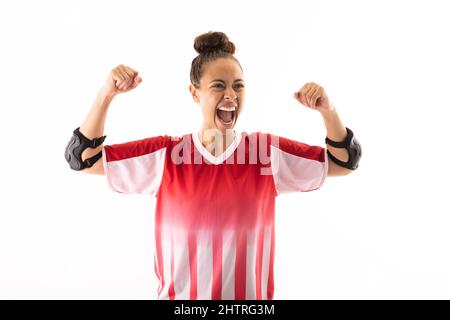 Joyeux biracial jeune femme joueur de handball avec le poing serré criant sur fond blanc Banque D'Images