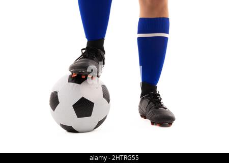 Coupe basse de jeune femme biracial debout avec le pied sur le ballon de football sur fond blanc Banque D'Images