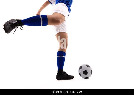 Coupe basse de la femme biracial joueur de football kicking football ball sur fond blanc Banque D'Images