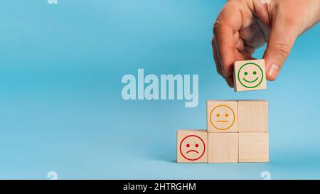 Main choisit smiley visage croissance sur le cube de bloc de bois, le meilleur exc Banque D'Images