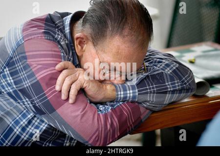 Dans Little Havana à Miami Florida sur la Calle Ocho, 7th rue dans l'après-midi - penser, rêvant de dormir triste homme Banque D'Images