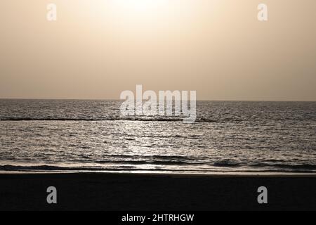 Une vue sur le coucher de soleil sur l'océan Atlantique, à Costa Adeje, Tenerife, Espagne, avec les faisceaux étincelant du soleil se reflétant sur l'océan Banque D'Images