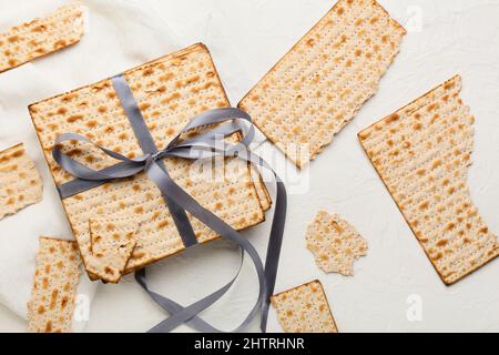 matza juif à pain plat pour la Pâque avec ruban et serviette sur fond blanc Banque D'Images