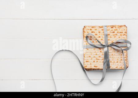 matza à pain plat juif pour la Pâque avec ruban sur fond blanc en bois Banque D'Images