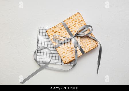 matza juif à pain plat pour la Pâque avec ruban et serviette sur fond blanc Banque D'Images