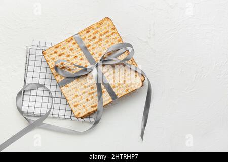 matza juif à pain plat pour la Pâque avec ruban et serviette sur fond blanc Banque D'Images