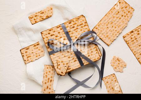 matza juif à pain plat pour la Pâque avec ruban et serviette sur fond blanc Banque D'Images