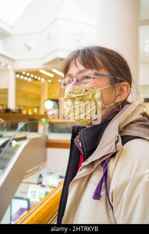 Gros plan d'une femme isolée portant un masque facial dans un centre commercial du Royaume-Uni. Banque D'Images
