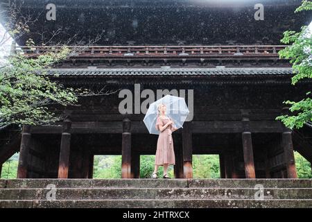 Fille asiatique en face du temple de Nanzenji au Japon sous la pluie Banque D'Images