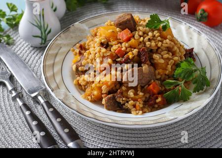 Bœuf avec boulgour et légumes tels que la citrouille, les carottes, les oignons et les tomates séchées Banque D'Images