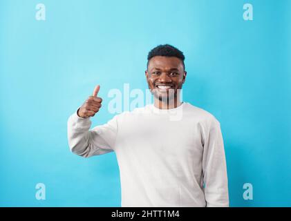 Jeune afro-américain portant des vêtements décontractés souriant heureux et positif, pouce vers le haut faisant excellent et signe d'approbation. Banque D'Images