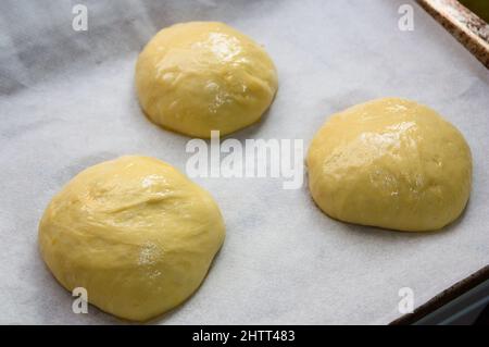 Gros plan d'une plaque de four avec trois panquemaos formés qui sont encore crus, typique des sucreries de Pâques à Valence (Espagne) Banque D'Images
