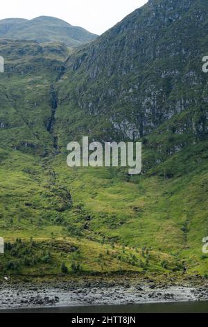 Une vue sur Lochan na Lairige jusqu'à une crête de montagne et une chute d'eau traversant le rocher, dans la chaîne de montagnes de Breadalbane à Glen Lyon près de Bebe Banque D'Images