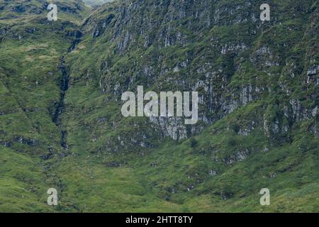 Une vue sur Lochan na Lairige jusqu'à une crête de montagne et une chute d'eau traversant le rocher, dans la chaîne de montagnes de Breadalbane à Glen Lyon près de Bebe Banque D'Images