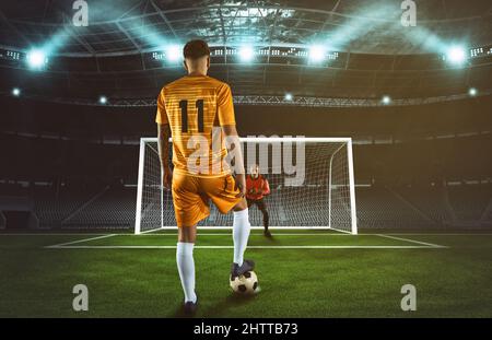 Scène de football de nuit avec un joueur en uniforme jaune donnant un coup de pied de pénalité Banque D'Images
