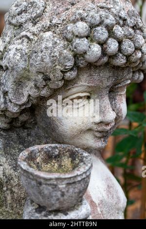 Petite figurine en pierre avec pot de fleur Banque D'Images