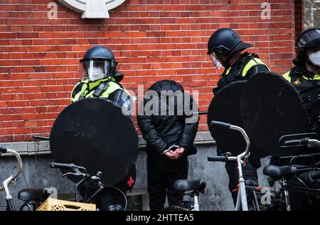 03-20-2021 police anti-émeutes hollandaise à Amsterdam, aux pays-Bas, avec un jeune homme menotté, arrêté lors d'une manifestation contre les covides Banque D'Images