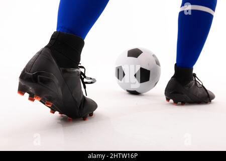 Gros plan sur une partie basse d'une joueuse biraciale jouant au football sur fond blanc Banque D'Images