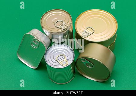 Groupe de boîtes en étain empilées avec bords vides sur fond vert.Aliments en conserve.Différentes boîtes en aluminium pour un stockage sûr et à long terme des aliments.Récipients étanches en acier pour l'entreposage des aliments Banque D'Images