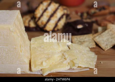 Fromage irlandais avec chocolat belge et macarons à la noix de coco italienne dans une cuisine rustique Banque D'Images