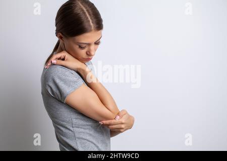 douleur au coude femme souffrant de douleur au coude sur fond gris Banque D'Images