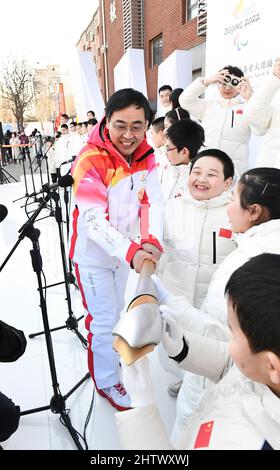 Pékin, Chine. 2nd mars 2022. Les élèves de l'École pour les aveugles de Beijing touchent la torche tenue par le porteur de flambeau Yao Yufeng pendant le Relais de la flamme paralymique de Beijing 2022 et la cérémonie d'éclairage de la flamme à l'École pour les aveugles de Beijing, capitale de la Chine, le 2 mars 2022. La flamme des Jeux paralympiques d'hiver de 2022 à Beijing a été collectée à huit endroits à Beijing et à Zhangjiakou. Chaque collection a été suivie d'un relais de pas plus de 20 porteurs de torches sur place avant la rencontre des flammes au Temple du ciel. Credit: Xia Yifang/Xinhua/Alay Live News Banque D'Images
