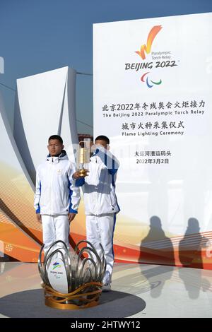 Pékin, Chine. 2nd mars 2022. Les membres du personnel montrent la flamme lors du relais de la flamme paralymique de Beijing 2022 et de la cérémonie d’éclairage de la flamme au quai du Grand Canal à Beijing, capitale de la Chine, le 2 mars 2022. La flamme des Jeux paralympiques d’hiver de Beijing 2022 a été recueillie à huit endroits à Beijing et à Zhangjiakou. Chaque collection est suivie d'un relais de pas plus de 20 porteurs de torches sur place avant le rassemblement de neuf flammes au Temple du ciel. Credit: Li Renzi/Xinhua/Alay Live News Banque D'Images