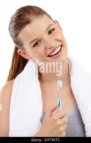 Des dents blanches étincelantes et un sourire éclatant. Une jolie adolescente tenant une brosse à dents et souriante. Banque D'Images