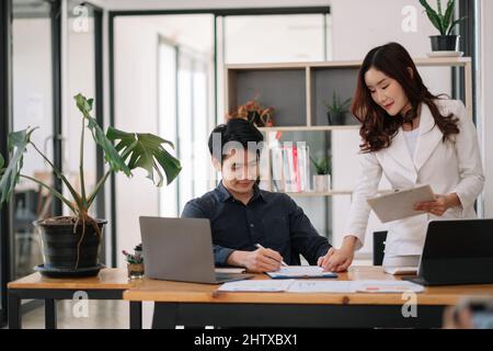 Réunion des conseillers d'affaires asiatiques pour analyser et discuter de la situation sur le rapport financier dans la salle de réunion.Consultant en investissement, financier Banque D'Images