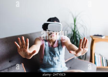 Jeune femme hispanique jouant et utilisant des lunettes de réalité virtuelle VR à la maison au Mexique Amérique latine Banque D'Images