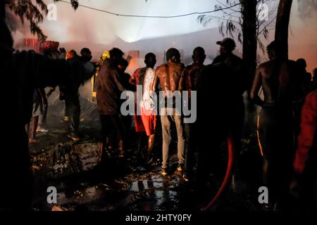 Nairobi, Kenya. 01st mars 2022. Les résidents ont du mal à mettre un feu de nuit qui a rasé les maisons laissant la plupart des familles sans abri pendant les heures de nuit à Kibera, Nairobi. Les habitants des bidonvilles de Kibera ont subi une autre perte, car ils ont été pris au dépourvu par un incendie qui s'est produit tard dans la nuit, razzant vingt maisons, laissant la plupart des habitants sans abri et n'ayant nulle part où se tourner vers. L'incendie était dû à des fils emmêlés provenant de connexions électriques illégales. Crédit : SOPA Images Limited/Alamy Live News Banque D'Images