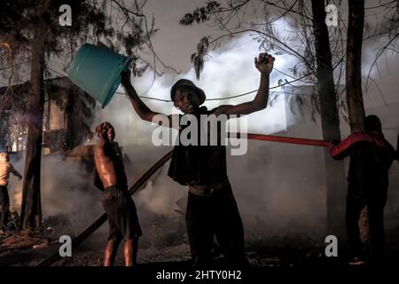 Nairobi, Kenya. 01st mars 2022. Un jeune garçon célèbre après avoir réussi à aider à faire feu dans les bidonvilles de Kibera à Nairobi.les habitants des bidonvilles de Kibera ont subi une autre perte puisqu'ils ont été pris au dépourvu par un incendie qui s'est produit tard dans la nuit, razzant vingt maisons, laissant la plupart des habitants sans abri et sans nulle part vers qui se tourner. L'incendie était dû à des fils emmêlés provenant de connexions électriques illégales. Crédit : SOPA Images Limited/Alamy Live News Banque D'Images