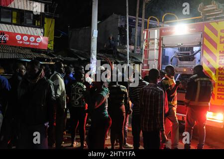 Nairobi, Kenya. 01st mars 2022. Les résidents regardent de loin tandis que les pompiers luttent pour faire feu dans les bidonvilles de Kibera. Les habitants des bidonvilles de Kibera ont subi une autre perte, car ils ont été pris au dépourvu par un incendie qui s'est produit tard dans la nuit, razzant vingt maisons, laissant la plupart des habitants sans abri et n'ayant nulle part où se tourner vers. L'incendie était dû à des fils emmêlés provenant de connexions électriques illégales. (Photo de Donwilson Odhiambo/SOPA Images/Sipa USA) crédit: SIPA USA/Alay Live News Banque D'Images