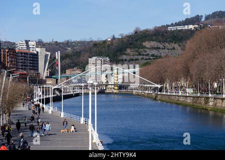 Bilbao, Espagne - 13 février 2022 : vue sur la promenade le long de l'estuaire de Bilbao. Passerelle Zubizuri par Santiago Calatrava Banque D'Images