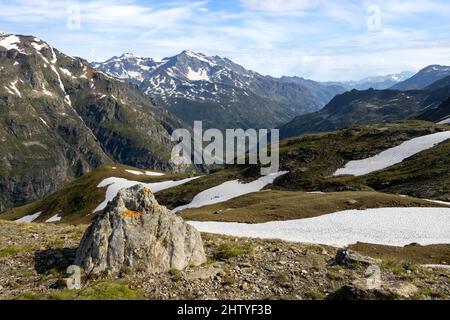 Randonnée dans la chaîne de montagnes d'Aoste à la fin du printemps avec des rochers typiques couverts de mousse d'orange Banque D'Images