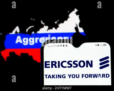 Dans cette illustration, le logo Ericsson est affiché sur l'écran d'un smartphone avec un drapeau de la Russie sous la forme d'une carte du pays avec l'inscription agresseur en arrière-plan. Ericsson a rejoint les sanctions contre la Russie. Banque D'Images