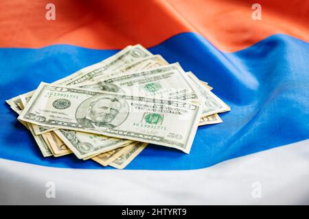 Billets EN dollars AMÉRICAINS mis sur le drapeau russe. Banque D'Images