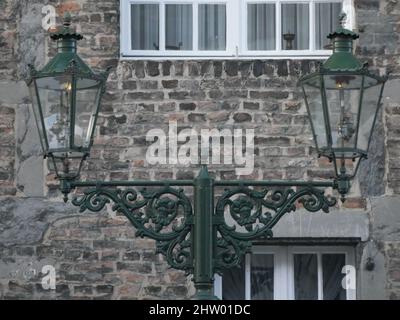De vieilles lanternes à gaz dans Kaiserswerth Allemagne bien entretenues et encore utilisées, un mur de s'émietter Banque D'Images
