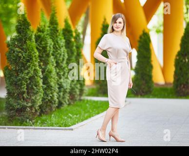 femme marchant dans la rue. Une dame dans une robe d'été élégante. Le concept de la mode féminine. Style de vie urbain. Jour ensoleillé Banque D'Images