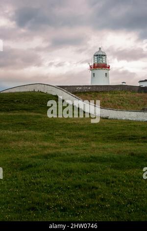 Phare sur la prairie verte de la côte du Donegal, Irlande. Banque D'Images