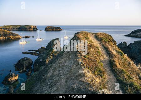 Un sentier mène à un point de vue sur un rocher sur la côte de l'île de Belle-ile-en-Mer sous le soleil du soir. Banque D'Images