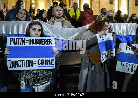 Tbilissi, Géorgie. 02nd mars 2022. Des manifestants russes tiennent des pancartes devant le Parlement de Tbilissi lors d'un rassemblement en faveur des Ukrainiens. Des manifestants se sont rassemblés devant le Parlement de Tbilissi dans un rassemblement pour soutenir le peuple ukrainien, où ils ont également livré des dons d'information sur la nourriture, les médicaments, les vêtements, les lits pour aider les Ukrainiens. Crédit : SOPA Images Limited/Alamy Live News Banque D'Images