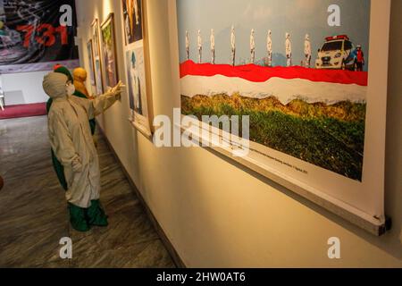 Bandung, Indonésie. 03rd mars 2022. Les visiteurs portant des combinaisons de protection contre les noisettes sont vus à l'intérieur de la Galerie lors de l'exposition pandémique de 371 jours à Bandung. Au total, 57 photos individuelles et quatre récits de photojournalistes indonésiens (PFI) Bandung ont été exposés à l'exposition de 371 jours de la pandémie en Indonésie, qui se tiendra jusqu'au 8 mars 2022. Crédit : SOPA Images Limited/Alamy Live News Banque D'Images