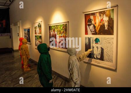 Bandung, Indonésie. 03rd mars 2022. Les visiteurs portant des combinaisons de protection contre les noisettes sont vus à l'intérieur de la Galerie lors de l'exposition pandémique de 371 jours à Bandung. Au total, 57 photos individuelles et quatre récits de photojournalistes indonésiens (PFI) Bandung ont été exposés à l'exposition de 371 jours de la pandémie en Indonésie, qui se tiendra jusqu'au 8 mars 2022. Crédit : SOPA Images Limited/Alamy Live News Banque D'Images