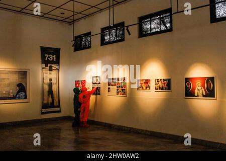 Bandung, Indonésie. 03rd mars 2022. Les visiteurs portant des combinaisons de protection contre les noisettes sont vus à l'intérieur de la Galerie lors de l'exposition pandémique de 371 jours à Bandung. Au total, 57 photos individuelles et quatre récits de photojournalistes indonésiens (PFI) Bandung ont été exposés à l'exposition de 371 jours de la pandémie en Indonésie, qui se tiendra jusqu'au 8 mars 2022. Crédit : SOPA Images Limited/Alamy Live News Banque D'Images