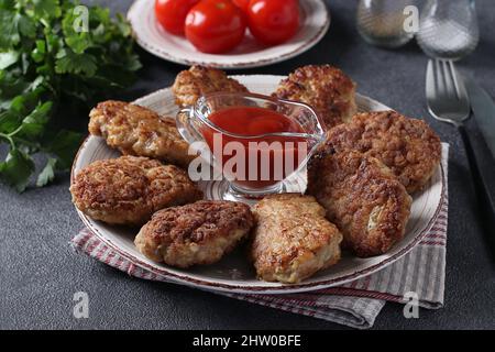 Côtelettes de filet de dinde et de flocons d'avoine, frites dans une casserole, servies avec de la sauce tomate Banque D'Images