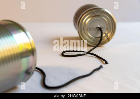 Deux boîtes de conserve avec une corde coupée entre elles suggérant une communication rompue.orientation Paysage Banque D'Images