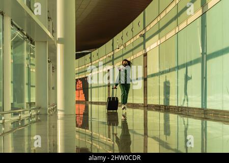 femme traversant l'aéroport Banque D'Images